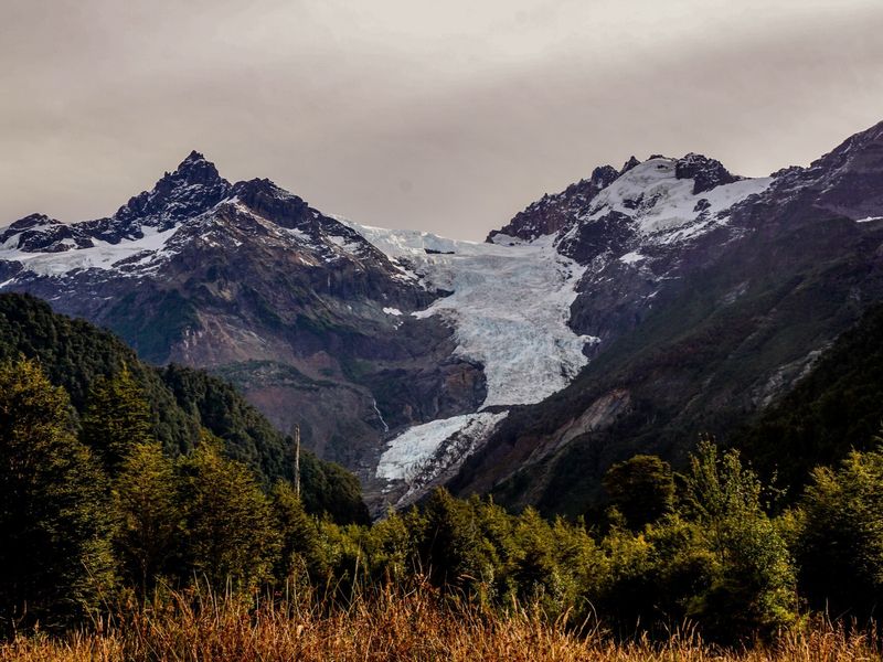 The Yelcho Glacier between snow-capped peaks and native forest